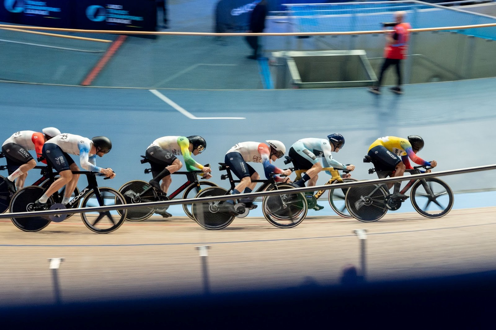 a group of track cyclists sprinting in the velodrome